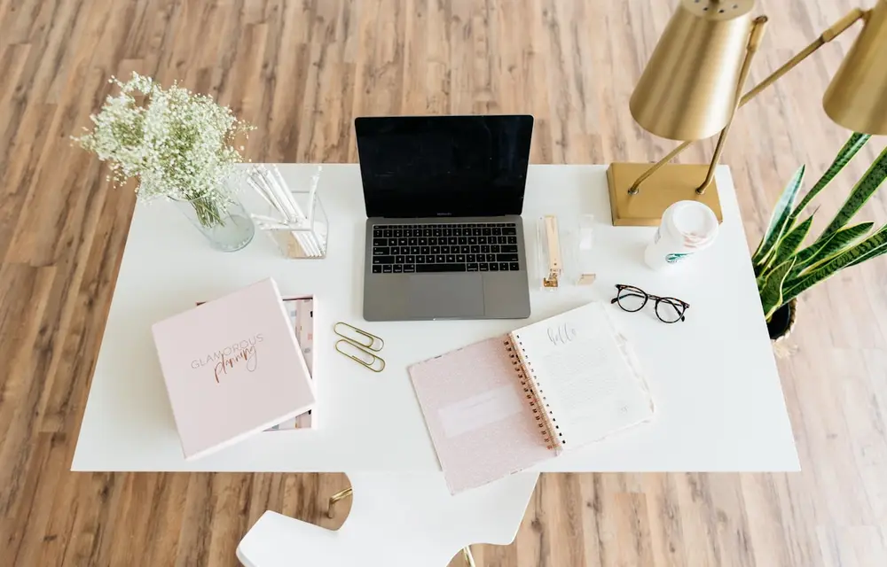 A laptop and papers on a kitchen table at home
